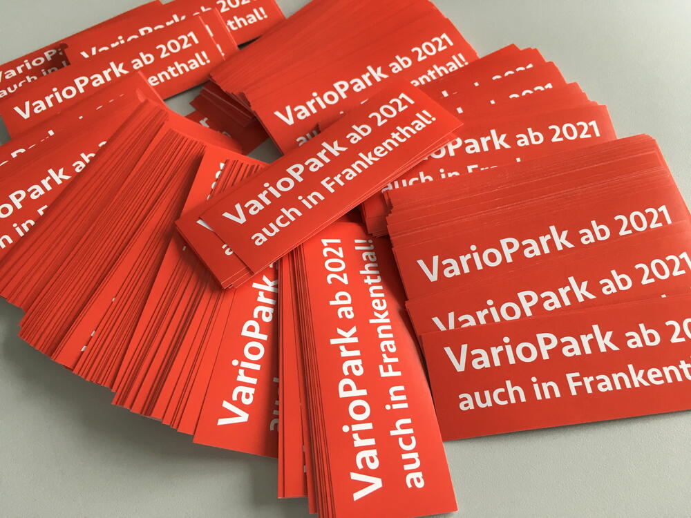 Aufgereihte rote Aufkleber mit dem Titel in weißer Schrift "VarioPark ab 2021 auch in Frankenthal"