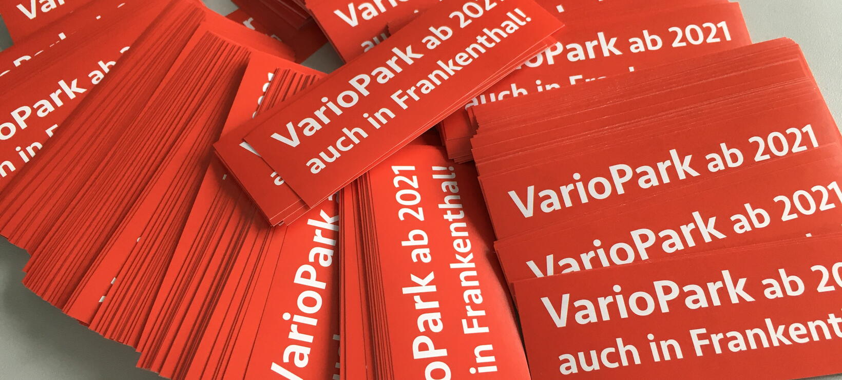 Aufgereihte rote Aufkleber mit dem Titel in weißer Schrift "VarioPark ab 2021 auch in Frankenthal"